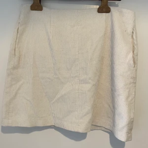 Vit manchesterkjol - Enabart provad vit manchesterkjol med fickor på vardera sida. 