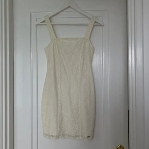 Studentklänning - Jättefin krämvit klänning i spets med kvadratisk ringning! Mäter 66cm från mitten på bröstet ned. storlek XS men skulle passa en S också. Köparen står för (spårbar) frakt!