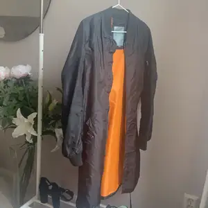A medium size alpha industries long jacket in black.
