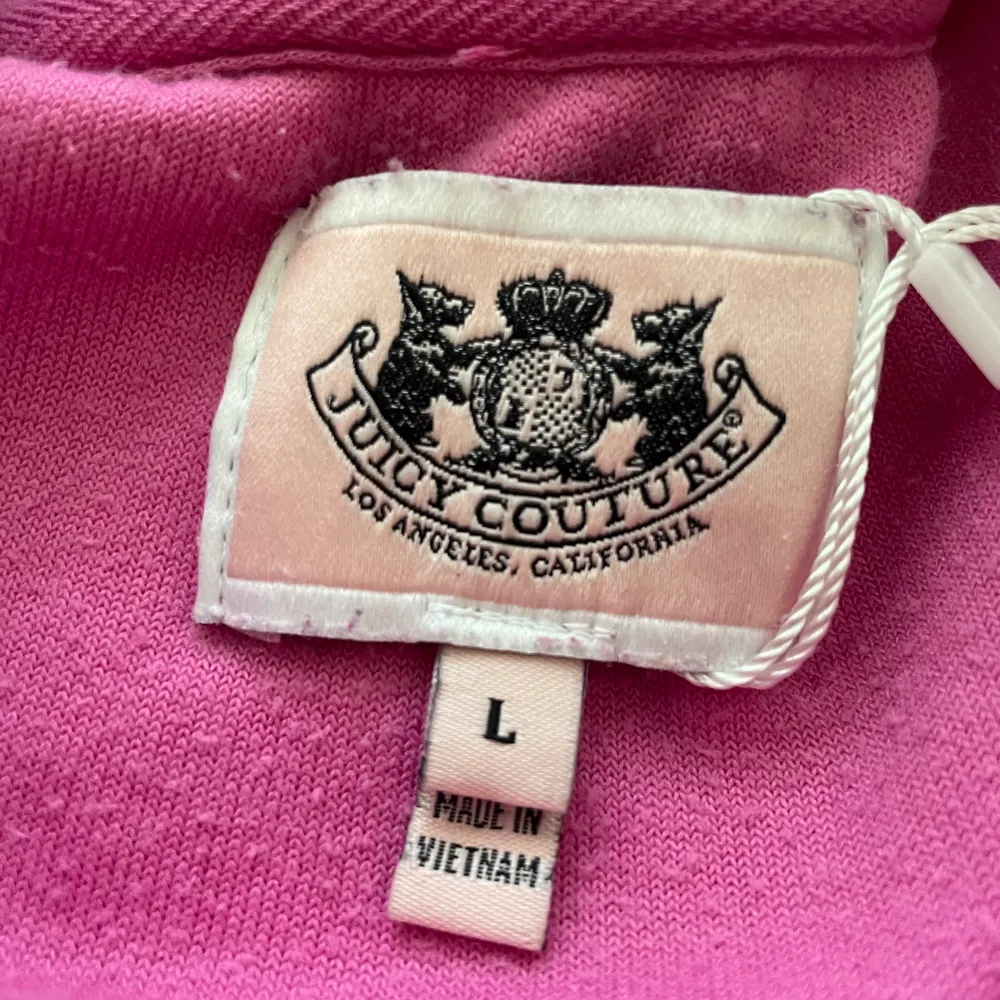 En sjuktsnygg Juicy Couture tröja. Den är rosa och coola detaljer på baksidan. Koftan har en dragkedja som fungerar och har en luva. Tecken på användning finns men lätt att fixa.Står att de är storlek L men skulle säga att den är en XS. Tröjan är croped.                                       ❗️KÖPAREN STÅR FÖR FRAKT❗️. Hoodies.
