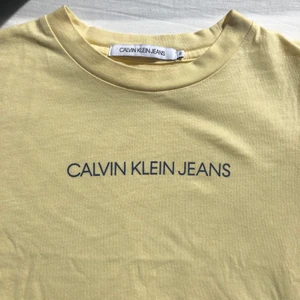 Gul Calvin Klein Jeans T-Shirt - Söt ljusgul Calvin Klein T-shirt, fint skick och använd ett par gånger, inga skador eller fläckar. Storlek S men passar som XS-S 
