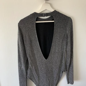 Glittrig body! - En fin och glittrig body med öppen rygg! Använd en gång. 