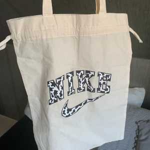 Nike tygpåse - Säljer denna skitcoola Nike tygväskan då den inte kommer till användning. Helt oanvänd. Köpt och målad av @designbysteenbackup på instagram. Tar endast swish, frakten ligger på 24kr. Startpris 50kr exklusive frakt!