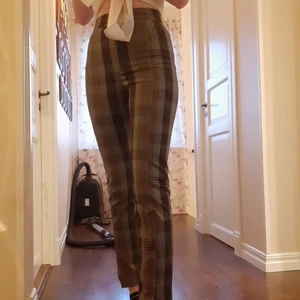 Rutiga byxor - Beiga/grå/bruna rutiga byxor från Monki. Säljer för att de tyvärr blivit för små. Har använt dem en del men de är i fint skick utan fläckar.