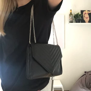 Svart väska  - Säljer min svarta väska från Ginatricot. Använd ett fåtal gånger och är i bra skick. Kan reglera bandet så det antingen är långt eller kort. Köparen står för frakten!