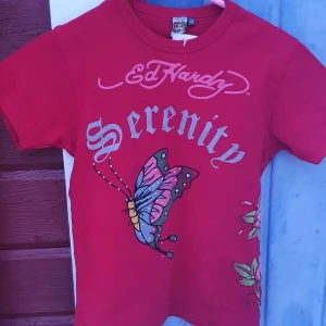 Ed hardy baby tee - En supersnygg ed hardy baby tee i superbra skick, buda!! (DEN ÄR MER RÖD I VERKLIGHETEN ÄN PÅ BILDEN!!) Öka med minst 10 kronor / bud  *BUDGIVNING SLUTAR ONSDAG 20:00* !!Köparen står för frakten!! Köp direkt för 200!!