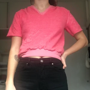 Rosa t-shirt - Säljer denna rosa t-shirt i frotté-material, köpt secondhand i Köpenhamn men kommer tyvärr inte till användning. Tröjan är i storlek L men den passar mig som vanligtvis har storlek S. Köpare står för frakt