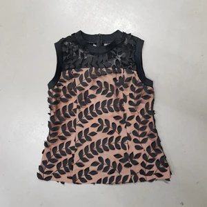 Blus svart, storlek 38 - Svart blus med fina detaljer. Tylltyg dekorerad med blad. Dragkedja bakom. Använd en gång. Fick mycket beröm på festen. Passar storlek 36-38.