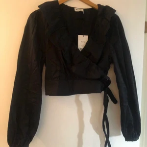 Jättefin omlott blus  - Superfin svart omlott blus köpt på NA-KD. Säljer pga inte min stil. Aldrig använd! Storlek 42 men passar även 40. Säljer en likadan i vitt! Kan skickas men köparen står för frakten!