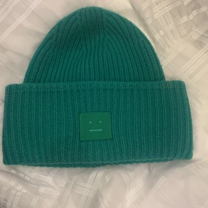 Grön acne mössa - Lägger ut igen då jag nu är helt hundra på att jag vill sälja!💓💓 superfin varm mössa som inte längre kommer till användning. Finns inte längre att köpa på deras hemsida så lite ovanlig. Ytterst liten fläck på baksidan på en av ”stickraderna”, säljer därför lite billigare. Skulle tro att den går att tvätta bort (obs endast handtvätt). Originalpris på 1200kr. Bara använd en vinter. Då detta är en dyrare produkt har jag spårbar frakt💓💓 !!ej fläck på framsida, det är en lampskugga!!