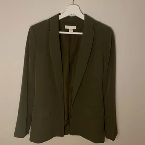 HM Blazer stl. 34 - En blazer från HM i nyskick, militärgrön färg, storlek 34. Avslappnad passform men inte oversized 