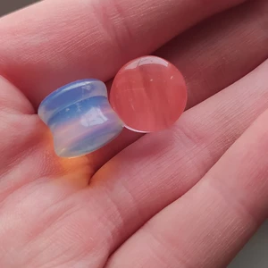 Två glas pluggar - Jättefina färger, mjölkvit/isblå och aprikos/korall. Priset gäller för båda,frakt 12:-