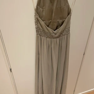 Festklänning från Nelly  - Säljer en ljusgrå festklänning, använd endast 2 gånger. Köparen står för frakten ,går även att möta upp. 