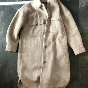 Helt ny beige lång skjortjacka kappa - Helt ny beige lång skjortjacka kappa från Gina Tricot. Strl xs men passar även större då den är stor i storlek. Perfekt nu i vår då den är lagom tjock. Går över mina knän som är 170cm lång. Nypris 800. 