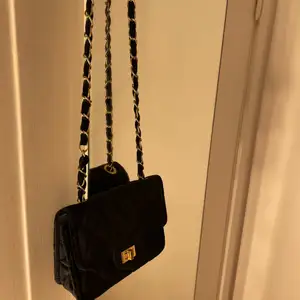 Liten handväska i svart sammetliknande material. osäker på vartifrån, nypris 600, användt 2 gånger