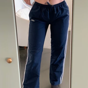 Blåa adidas byxor  - Lågmidjade byxor från Adidas. Köpt på Beyond Retro. Fortfarande i mycket bra skick. Jag är 175cm och dem går precis till mina fötter. Frakt ingår🌸🧚🏼🌈💗❣️