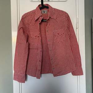 Säljer en röd rutig skjorta från girls casual wear collection av original rocky clothing som är en varumärke från 90s. Använd sparsamt och i fint skick. Storlek S.