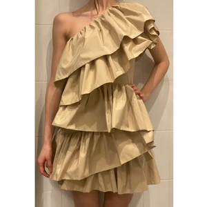 Beige volang klänning  - Super vacker klänning med dubblerade volanger ifrån H&M (Limited edition). Dold dragkedja i ena sidan. Tyvärr passar den inte mig. Helt i nyskick - prislapp på.                           Nypris: 1299                                                                          Tredje bild: Zara Larsson i samma klänning 