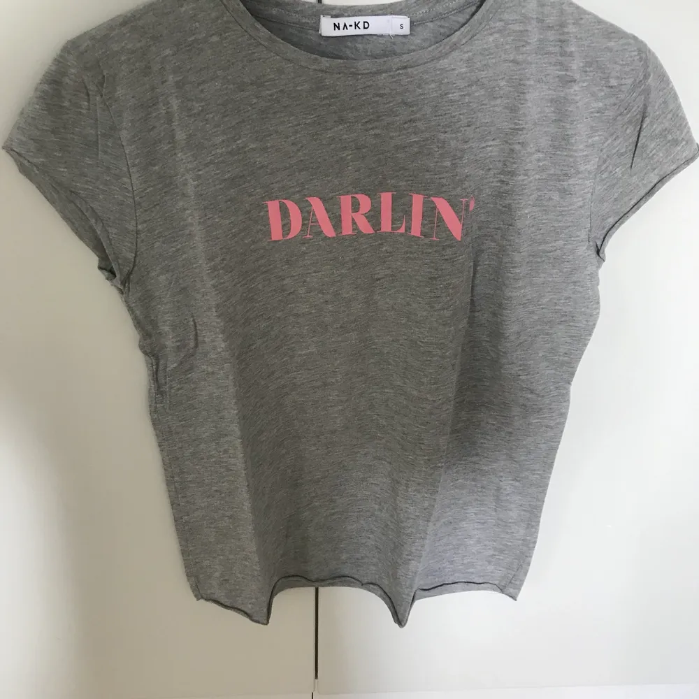 Grå t-shirt med rosa text DARLIN’. T-shirts.