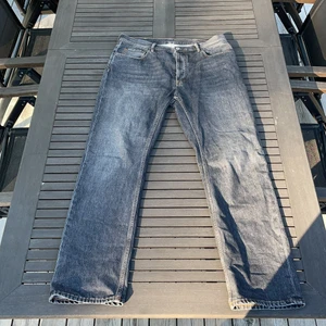 Mörk gråa Acne Studios jeans.  - Storlek 33/34. Påsybar logga ingår passform straight/Loose fit, nästan helt oanvända nypris 1995kr