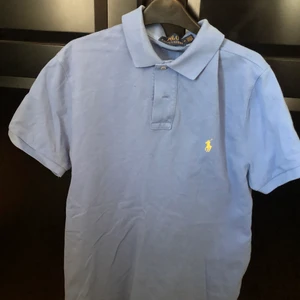 Ljusblå pike tröja ifrån Ralph Lauren  - Ljusblå pike tröja ifrån Ralph Lauren i 100% bomull.  Slim fit modell - Storlek M  I väldigt fint skick. Mitt pris 350kr inkl Nypris ca 1000kr