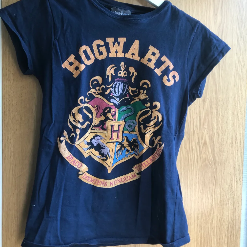 Fin t-shirt med tryck med Hogwarts logga, i storlek S men jag skulle säga storlek XS, den passar även på S men då blir det lite tajt❤️. T-shirts.