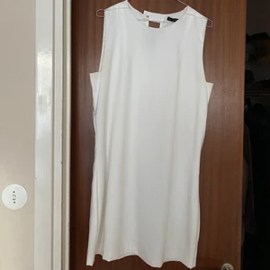 Vit klassisk klänning - Klassisk, vit kort klänning med knäppning i ryggen från Zara. Storlek L, passar M. Använd en gång i samband med student för flera år sedan.