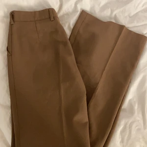 Bruna vida kostymbyxor - Vida 70-tals byxor med pressveck. Dem är ungefär midwaist skulle jag säga. Själva byxorna är i fint skick men knappen i fram är av, men går lätt att sy dit en ny, dragkedjan funkar men är lite trög. Köpta second hand, men jag har aldrig användt dem då dem är för stora för mig. Väldigt långa på mig som är 158. Skulle säga att dem är i storlek S💕