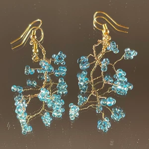 Handgjorda örhängen  - Detta par är en personlig favorit!!  Handgjorda med blå/ turkosa glaspärlor!!!! Ca 5 cm med tvinnad guldig ståltråd som bas, dock ”mjuka” i modellen och helt justerbara:)  ************************** Kolla gärna in min profil där jag har en massa mer smycken utlagda!! Frakt ingår i priset, perfekta för dig som vill sätta en personlig prägel på stilen eller att ge bort i present 🔮💕🧿