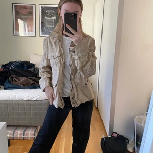 Jacka  - Beige jacka med massa olika fickor och detaljer. Storlek M men passar även S och XS! Aldrig använd 