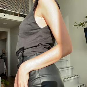 Svart T-shirt  - Svart T-shirt utan ärmar med vaddar på axlarna.