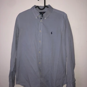 Ralph Lauren skjorta  - Säljer en ljusblå Ralph Lauren skjorta i Strl 18, slimfit. (Sitter som S) Inga fläckar, cond 8/10. Bud från 120. Nypris ca 1000kr 