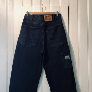 LEE for WEEKDAY - Ett par supercoola jeans från LEE for Weekday. Hög midja och väldigt vida ben med snygga snickardetaljer. Ca stl 30 i midjan, 33längd