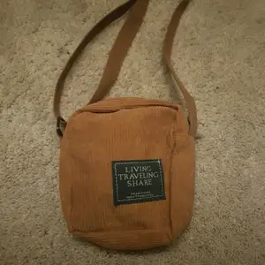 En fyrkantig carduroy/ manchester väska som är snygg. Går att justera på hur lång man vill ha den.