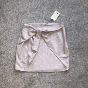 En glittrig kjol med knytning som aldrig kommit till användning med prislapp kvar ifrån bikbok. I storlek S men skulle säga att den är ganska stor i storleken. Pris diskuteras tillsammans 💕