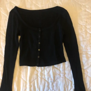 Svart tröja med knappar - Svart tröja med knappar på framsidan, köpt på Shein för ca 80kr för 1 år sedan. Skulle säga att den är i storlek xs/s och väldigt stretchig och skulle kunna passa upp till storlek L beroende på hur du vill att den ska sitta.                Du står för frakten💓 betalning via swish💓