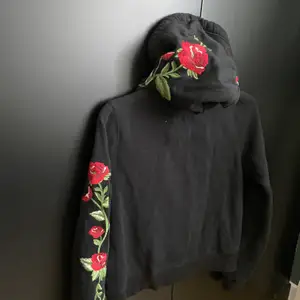 Har en hollister hoodie som är svart med röda rosor på. Rosorna går längst armarna och på luvan. Är i storlek S men är i kortare modell.