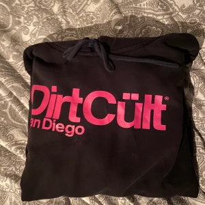 Svart dirtcult hoodie - Säljer en svart dirtcult hoodie med rosa text i storlek L men passar mer en M/S. Använd hyfsat mycket men syns ej alls, inga hål eller fläckar. Nypris 699kr säljer för 150kr. Köparen står för frakt.