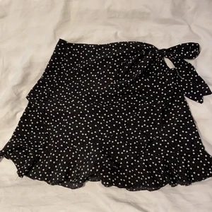 Svart volang kjol - Endast använd ett fåtal gånger. Svart med små vita hjärtan och ett knyte på sidan. Skriv för fler bilder💞💞