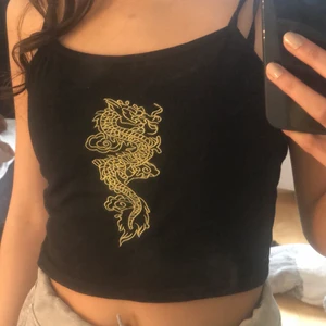 Svart linne med tryck - Ett svart ganska tunt linne med grönt tryck. Använd endast ett fåtal gånger, säljer då den inte kommer till användning längre. Fri från fläckar. Frakt tillkommer🥰