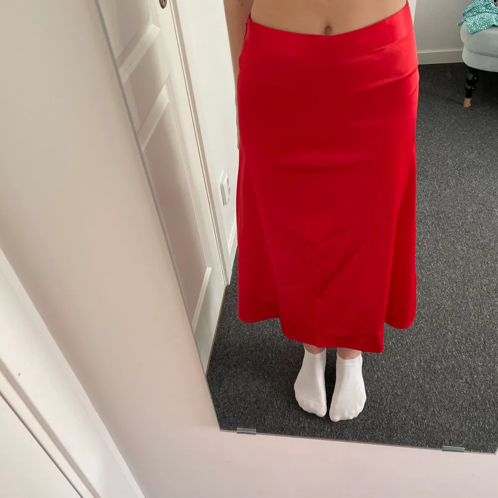 En röd kjol i midi-längd från Nakd. Jättehärlig röd färg. Materialet är silke som är jätteskönt. Endast använd en gång. Dragkedja på sidan. Kan passa flera storlekar i midjan beroende på om man vill ha kjolen högt eller lågt, jag är en xs. . Kjolar.