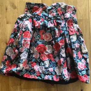 Blommig kjol med knappar bak tunn och medellång. Aldrig använd.
