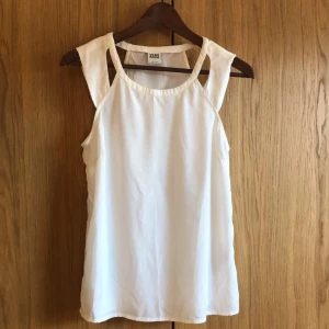 Vitt linne från Veromoda - Tunn och fin sommarlinne med snygga detaljer i axlarna. Passar perfekt till jeans eller kjol/shorts. Veromoda. Storlek: S Färg: vit Pris: 40kr + frakt