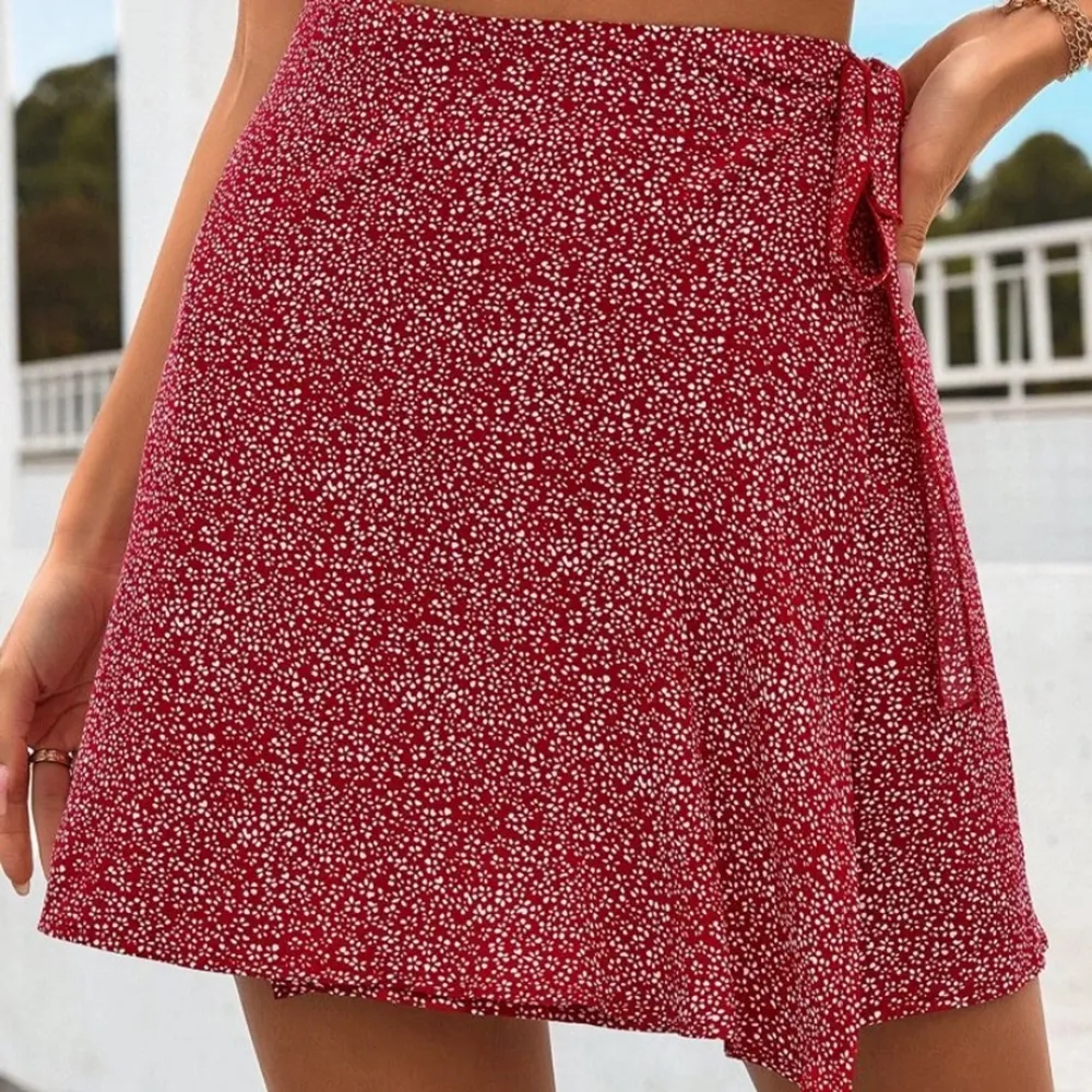 En röd blommig jättefin kjol som används 1 gång, frakt tillkommer❤️. Kjolar.