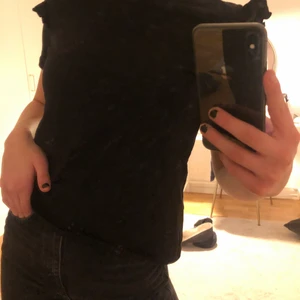 Svart t-shirt - Svart t-shirt med volang på axeln från Zara. Använd någon enstaka gång. Ser helt ny ut. 70kr + frakt 