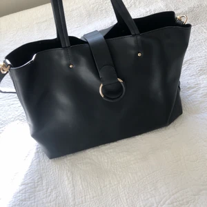 Väska - Stor och rymlig väska, med ett längre band till som man kan sätta på eller ta bort. Guldiga detaljer. Knappt använd.