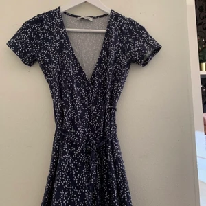 Blommig klänning - En marinblå blommig klänning som du knyter själv i midjan. Super fin till sommarn o även ha som kjol me en hoodie över. Den är lite liten på mig nu