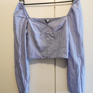 Kort topp med puffärm och smock  - Endast använd en gång. Från ASOS, storlek Medium (skulle även säga att den passar Small). Smock i ryggen. "Jeans"-färgad. Frakten är lagd som spårbart, kan säkert bli billigare med vanligt porto☺️