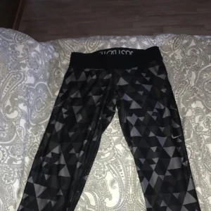 Gråa tights ifrån Nike. Använts några gånger. Inga slitningar. De slutat strax nedanför knät/mitt på vaden. Storlek S/36. Snörning i linningen. Har en liten ficka bak på höger sida. - Har ej slitningar. Fickan bak funkar normalt. De är dri-fit leggings. Slutar strax nedanför knät/mitt på vaden.