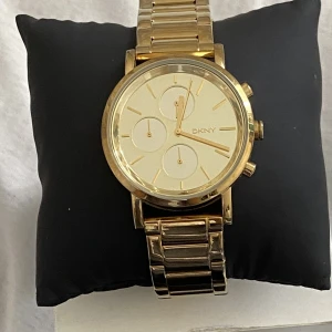 DKNY klocka  - DKNY klocka i fint skick   32 mm i helt guld och extra länkar med box tillkommer 